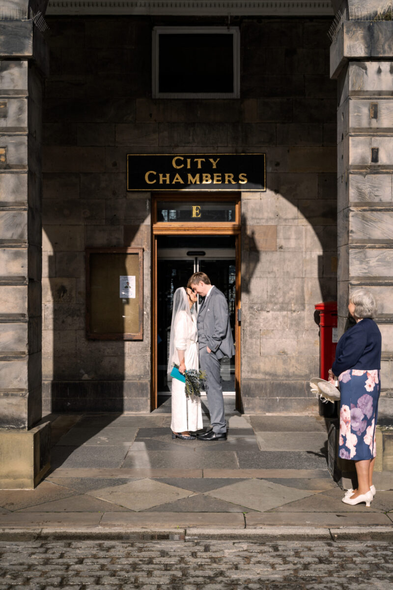 Scottish bride and groom outside city chambers kissing
